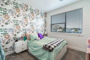 Bedroom featuring baseboards and dark colored carpet