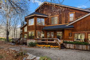 Rear view of property with roof with shingles