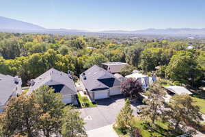 Aerial view of residential area with a mountain backdrop and a heavily wooded area