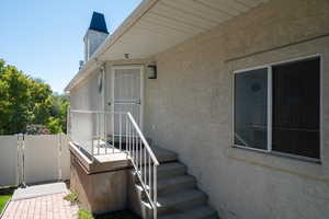 Doorway to property featuring stucco siding and a gate