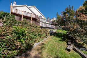 View of green lawn with a wooden deck