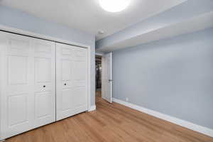 Unfurnished bedroom featuring light wood-style flooring and a closet