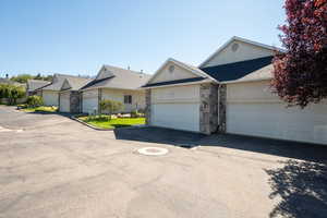 Ranch-style house featuring stone siding and asphalt driveway