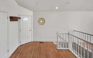 Entryway with wood finished floors and recessed lighting