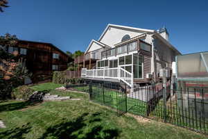 Back of house featuring a fenced backyard, a wooden deck, a patio, and stucco siding