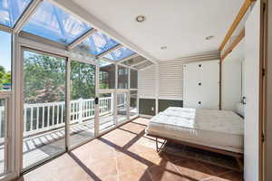 Bedroom featuring access to exterior, expansive windows, a sunroom, and recessed lighting