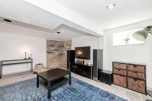 Carpeted living room with a textured ceiling and recessed lighting