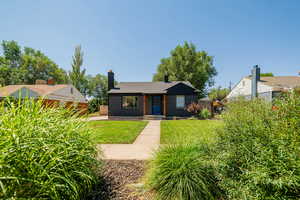 Bungalow with a chimney, brick siding, and roof with shingles