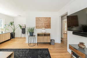 Living area with light wood finished floors and crown molding
