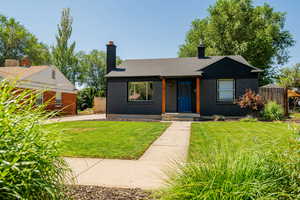 Bungalow-style house with a chimney, brick siding, and a shingled roof