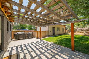 Fenced backyard with a patio, a pergola, and grilling area