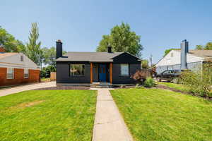 Bungalow featuring a chimney and brick siding