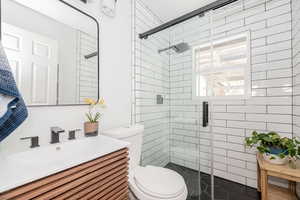 Bathroom featuring a shower stall and vanity