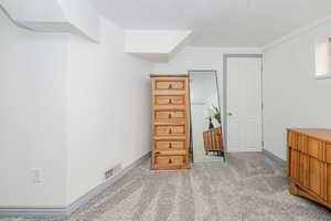 Bedroom with light carpet and a textured ceiling