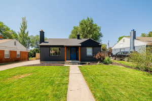 Bungalow featuring a chimney and brick siding