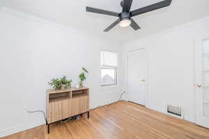 Living area featuring ornamental molding and light wood-type flooring