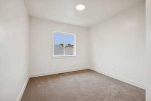 Empty room featuring light colored carpet and baseboards