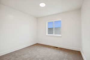 Carpeted spare room with baseboards