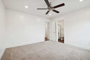 Unfurnished bedroom featuring dark carpet, ceiling fan, recessed lighting, and ensuite bath