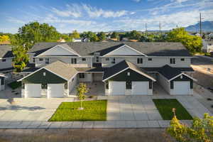 View of front facade with stone siding, driveway, and a mountain view