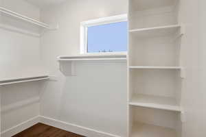 Spacious closet with dark wood-style floors