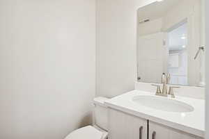 Half bathroom with vanity and toilet