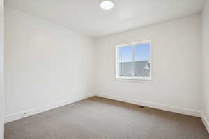 Empty room featuring carpet flooring and baseboards