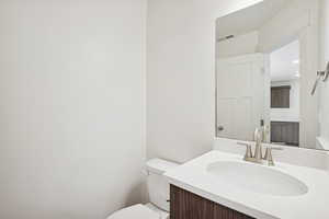 Half bathroom featuring vanity and toilet