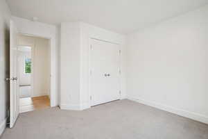 Unfurnished bedroom with carpet flooring and a closet