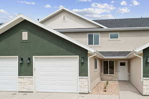 Traditional-style home featuring stucco siding and stone siding