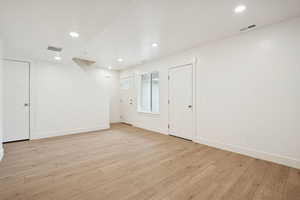 Empty room featuring light wood finished floors and recessed lighting