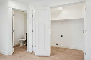 Laundry area featuring light wood finished floors, hookup for an electric dryer, and hookup for a washing machine