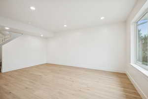 Basement featuring stairway, light wood finished floors, and recessed lighting