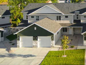View of front of house with stone siding, driveway, and a mountain view