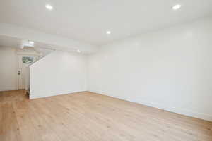 Below grade area with light wood-style flooring, recessed lighting, and stairs