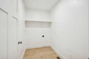 Laundry area featuring light wood-style flooring and hookup for an electric dryer