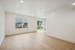 Empty room featuring light wood-style flooring and recessed lighting
