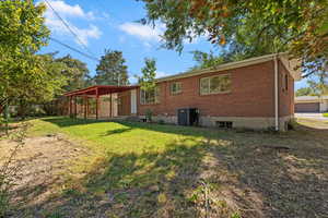Back of property featuring a yard, a patio, and brick siding