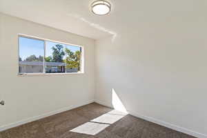 Carpeted empty room featuring baseboards