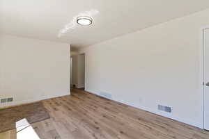 Unfurnished room with light wood-style flooring and baseboards
