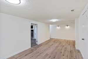 Basement with a textured ceiling and light wood finished floors