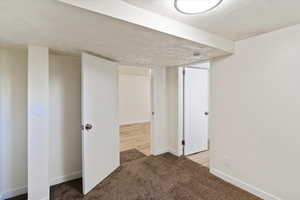 Below grade area featuring baseboards and light carpet
