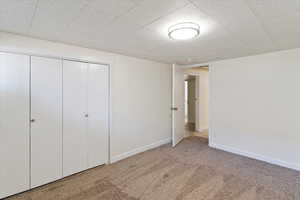 Unfurnished bedroom with a closet and light carpet