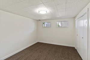 Unfurnished bedroom with dark colored carpet and a closet