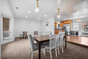 Dining room with light carpet, a chandelier, recessed lighting, and light tile patterned flooring