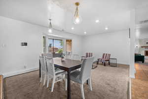 Dining room with baseboard heating, light carpet, recessed lighting, a textured ceiling, and a fireplace