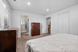 Bedroom featuring light colored carpet, recessed lighting, a closet, light tile patterned flooring, and stainless steel refrigerator