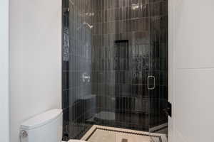 Bathroom featuring a stall shower and toilet