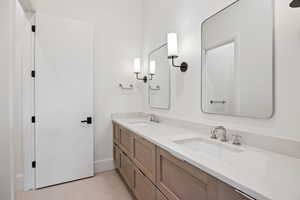 Bathroom featuring double vanity and baseboards
