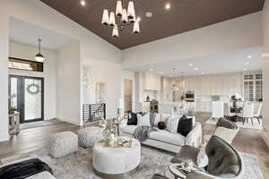 Living area with light wood-style floors, recessed lighting, a chandelier, and wood ceiling